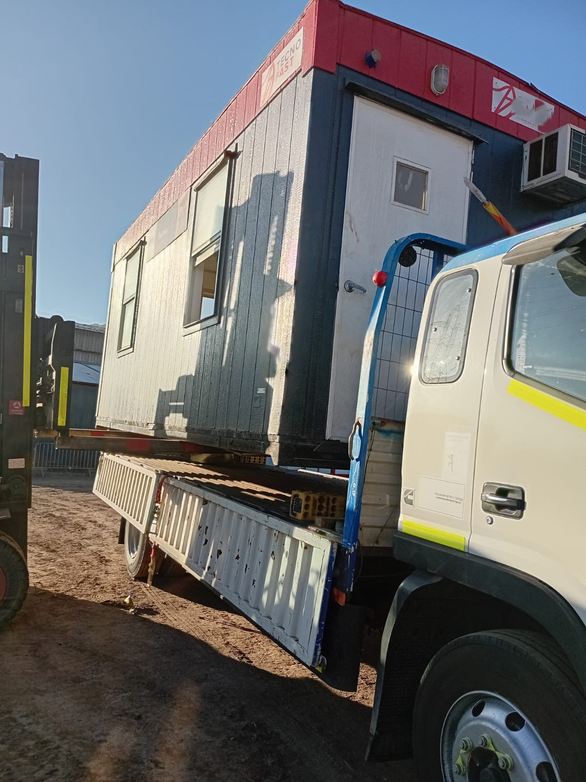 Operación de carga de contenedor modular sobre camión pluma